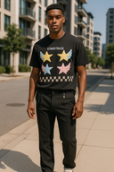 Young man wearing luxury black designer t-shirt with colorful winged star graphics and STARSTRUCK branding, featuring premium StarFlex fabric construction and celestial artistic design in urban setting