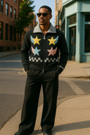 A man wearing Luxury black designer cardigan with multi-colored winged star embroidery in yellow, blue, and pink, featuring grey ribbed collar and premium StarFlex knitwear construction.